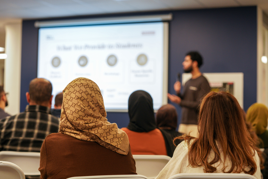People sitting and listening as a speaker gives a talk